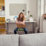 Junge Frau sitzt entspannt im Studentenzimmer | Terrassenüberdachung